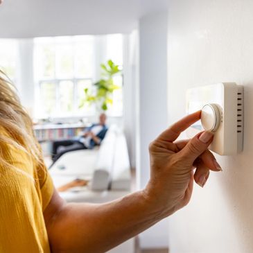 A vibrant city skyline at sunset with clouds and lights illuminating the buildings.