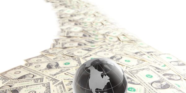 Globe on a path of US dollar bills.