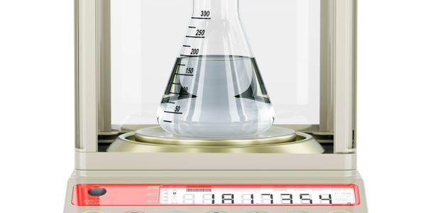 Analytical balance weighing a flask with liquid inside a protective enclosure.