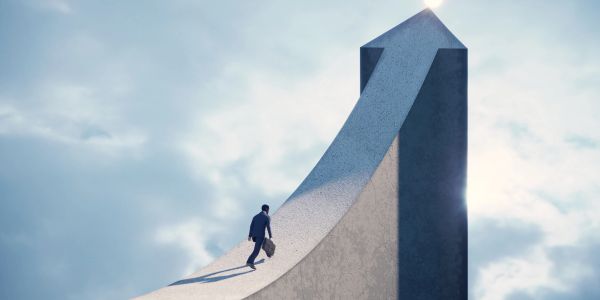 Hombre de negocios subiendo una curva empinada hacia la cima.