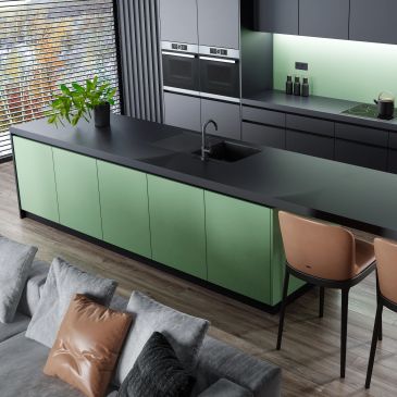 Modern kitchen with green cabinets and black countertops.