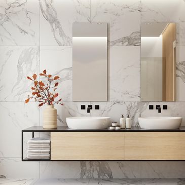 Modern bathroom with double sinks and marble walls.