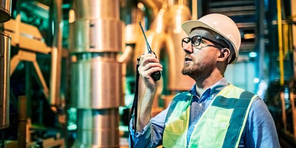 Engineer using walkie-talkie in a factory.