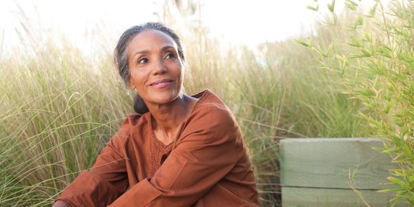 Woman sitting outside in natural setting.