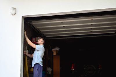 Worn-out garage door weather stripping: cracked rubber seals on door edges, peeling paint.


 