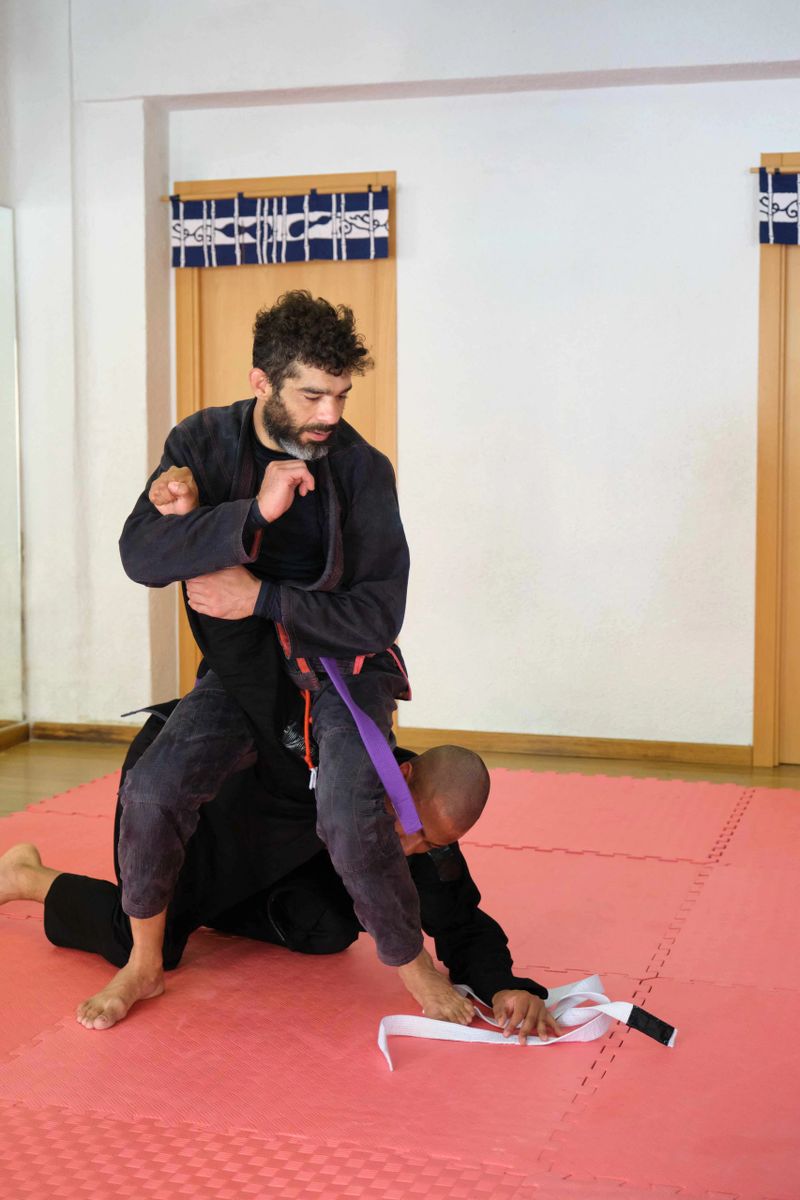 Two men practicing Brazilian Jiu-Jitsu fighting at the School. BJJ training.