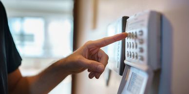 Person entering a code on a security keypad.
