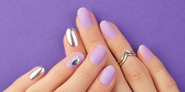 Matte lavender nails with silver chrome accents and a silver ring on a purple background.