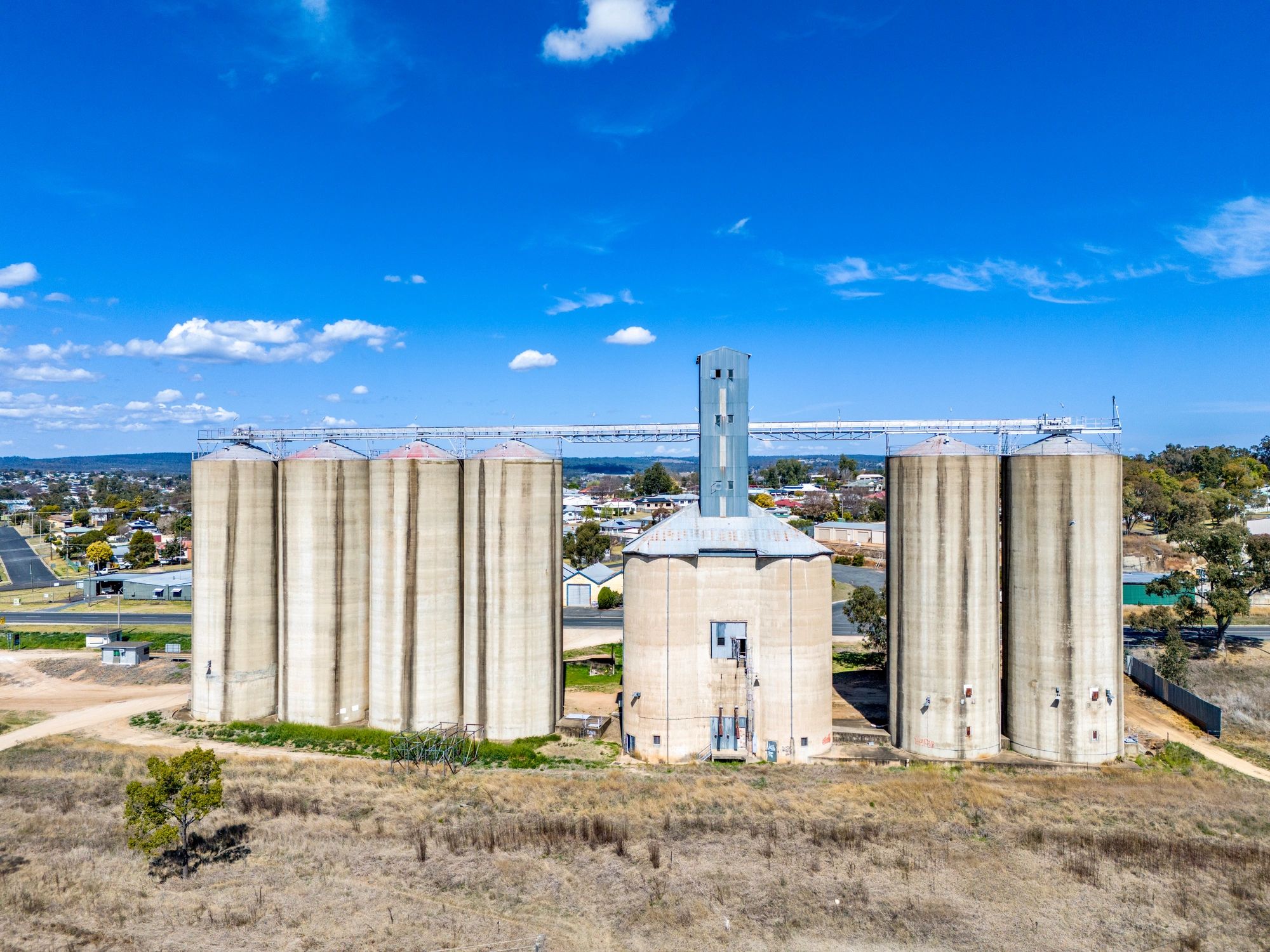 Large concrete grain silos under a clear blue sky.
