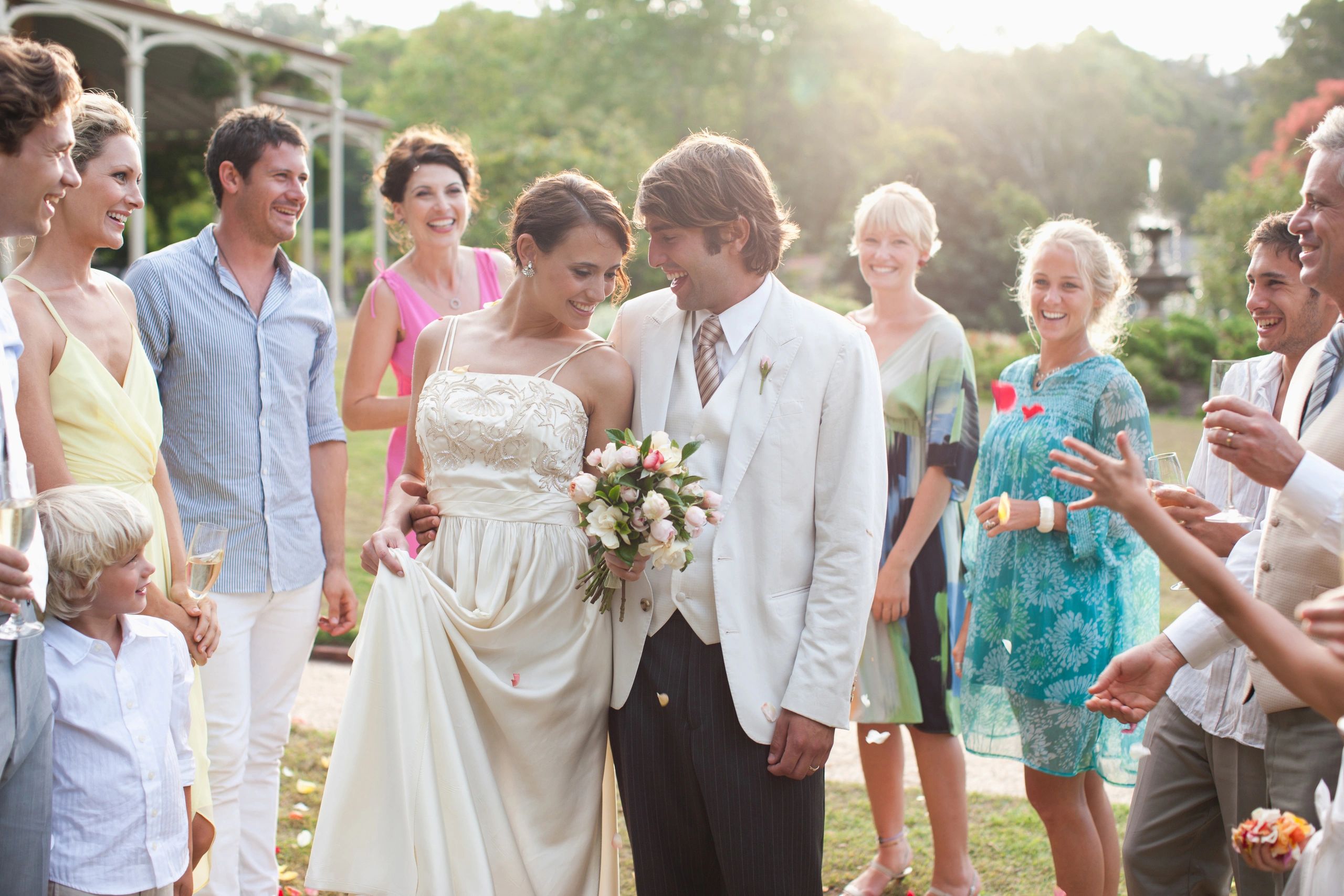 Happy bride and groom surrounded by smiling guests.