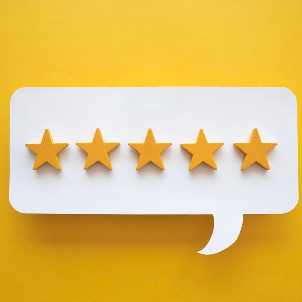 Five golden stars inside a white speech bubble on a yellow background.