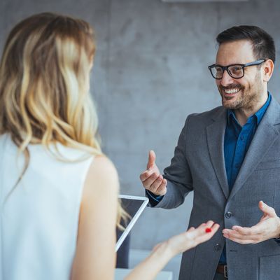 Two professionals having a friendly conversation in an office.