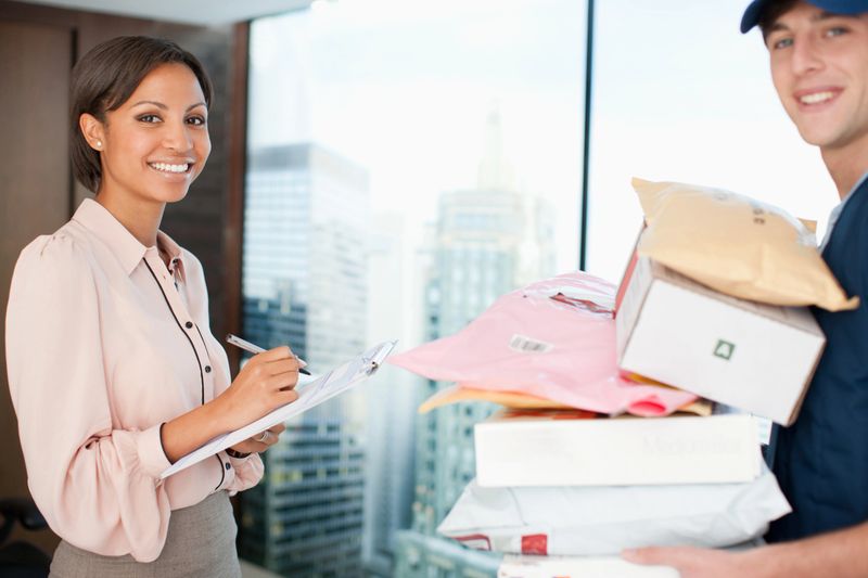 Businesswoman signing for packages in office