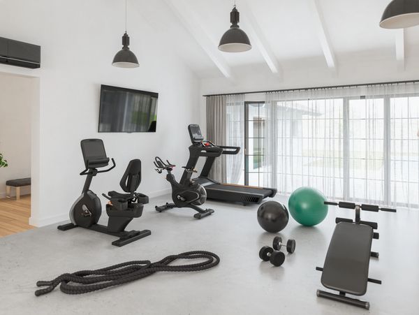 Bright home gym with exercise equipment and large windows.