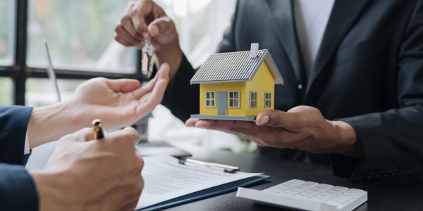 Real estate agent handing over house keys.