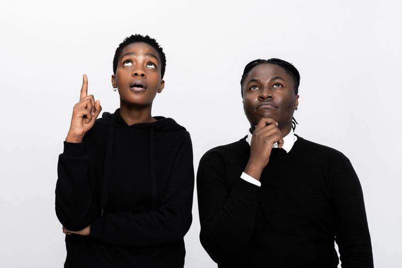 Curious african american black woman and man thinking considering of buying new home car. Thoughtful girl has an idea showing index finger looking up different thought in mind.