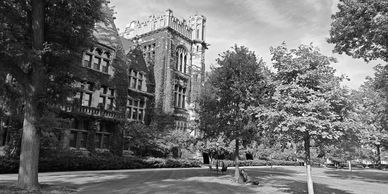 Historic university campus building surrounded by trees.