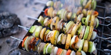 Vegetable skewers grilling on a barbecue.
