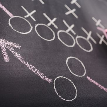 Diagram of gender symbols and arrows on a chalkboard.
