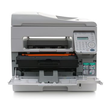 A gray multifunction printer with an open paper tray and control panel.