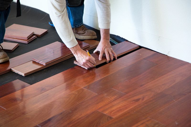 A worker installing hardwood floor in an American upscale home.A worker installing hardwood floor in an American upscale home.
