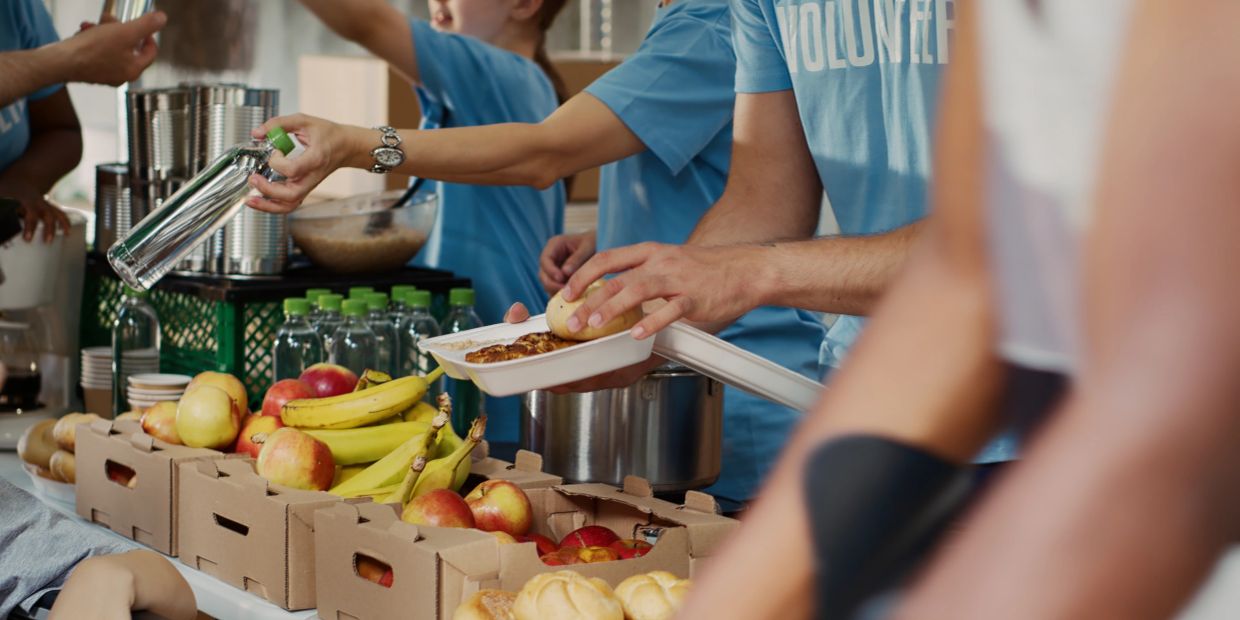 Volunteers serving food and drinks at a charity event.