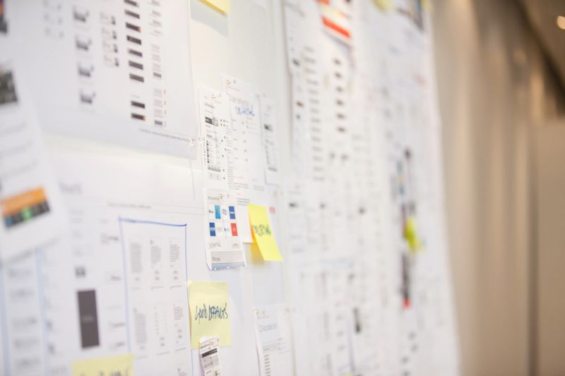 Documents and adhesive notes on wall in office