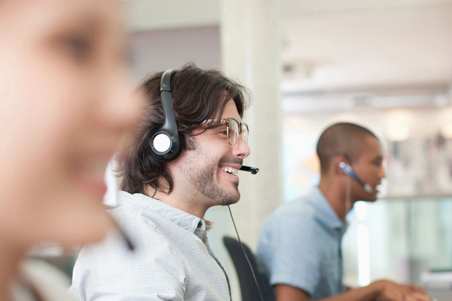 Customer service representatives working with headsets in an office.