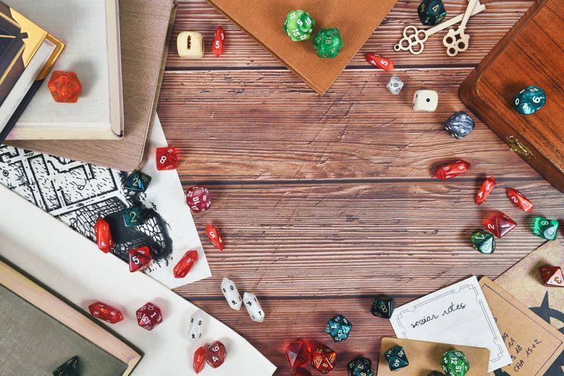 Tabletop role playing flat lay background with colorful RPG dices, rule books and notes on wooden background with copy space in middle