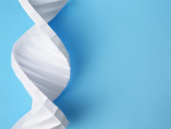 Paper folded into a DNA double helix shape on a blue background.