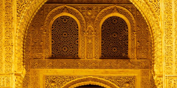 Intricately carved golden archway with geometric window patterns.