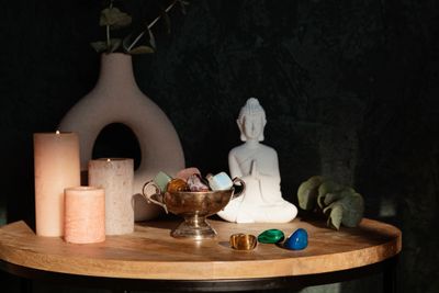A serene meditation setup with candles, crystals, and a Buddha statue.