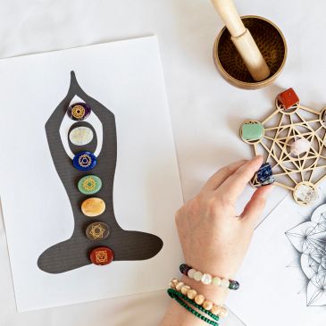Yoga chakra layout with crystals and spiritual tools.