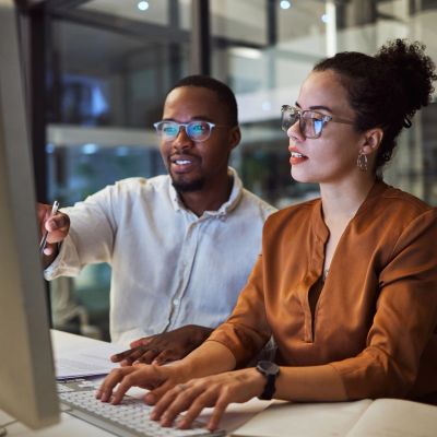 Two colleagues working together at a computer.