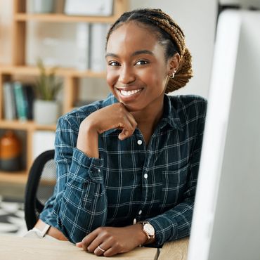 Confident woman smiling while working at her desk.