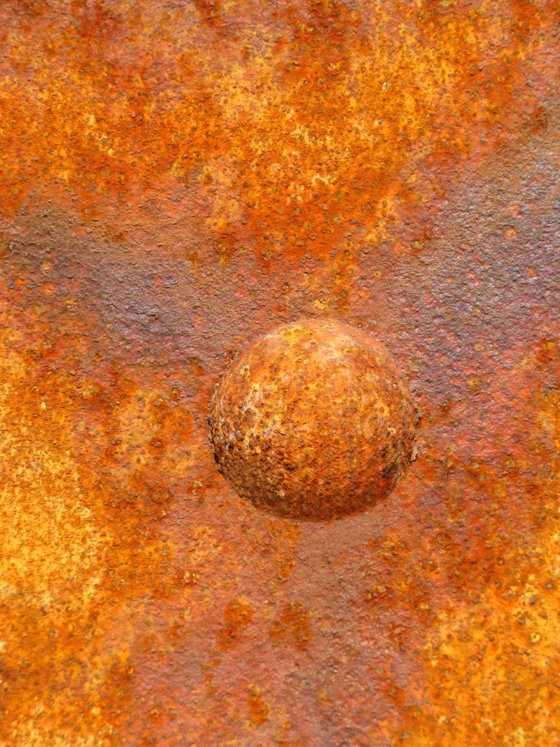 This detail from a rusted box car looks more like an image from the Hubble space telescope.The focus is on the rivet.This  image  came straight from the camera with no filtering. Some shadow removed in Photoshop.