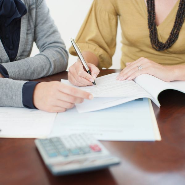 Two people reviewing and signing documents.