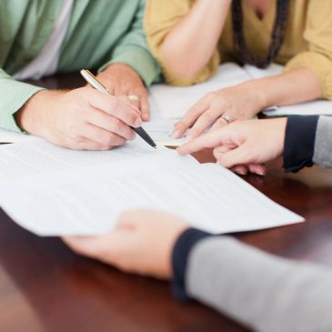 People reviewing and signing a document together.
