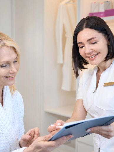 A skincare specialist consulting with a client in a spa setting.