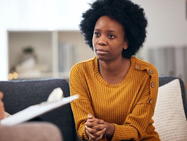 Woman in a yellow sweater attentively listening.
