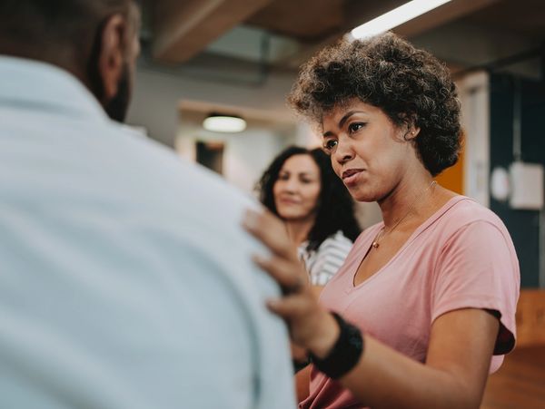 Woman showing support to a man in a serious conversation.