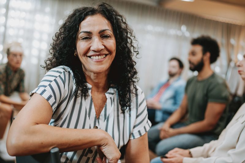 Portrait of a smiling woman in group therapy