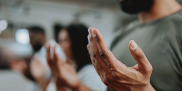 People praying with hands raised.