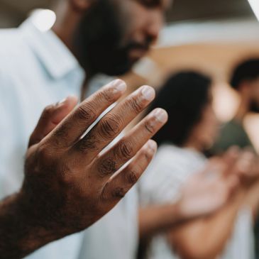 Close-up of hands raised in prayer or meditation.