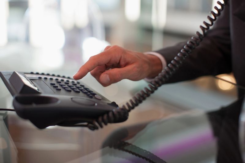 Businessman dialing telephone in office