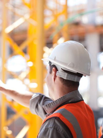 Dos ingenieros en casco y chaleco en una construcción.
