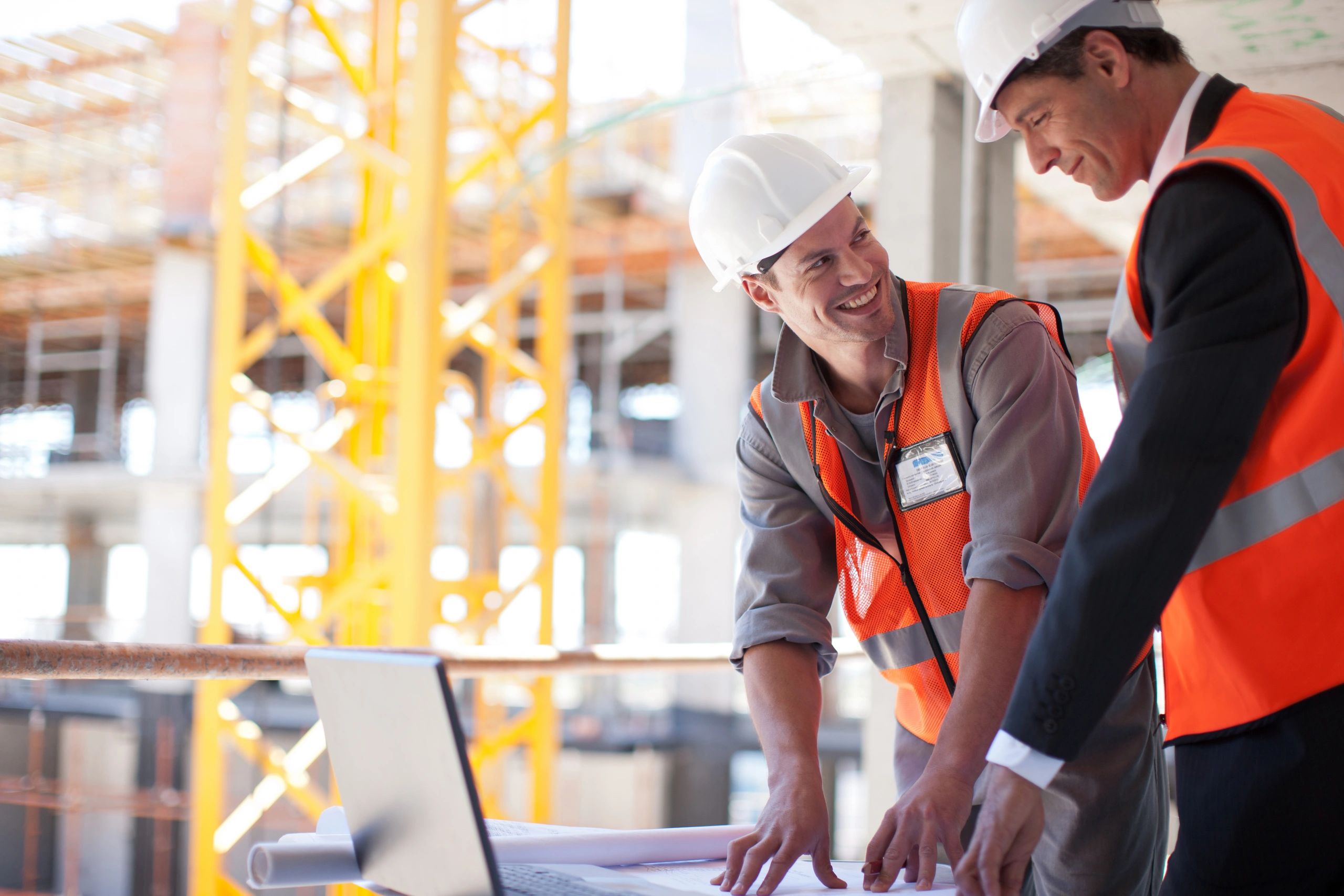 Two construction workers discussing plans on site.