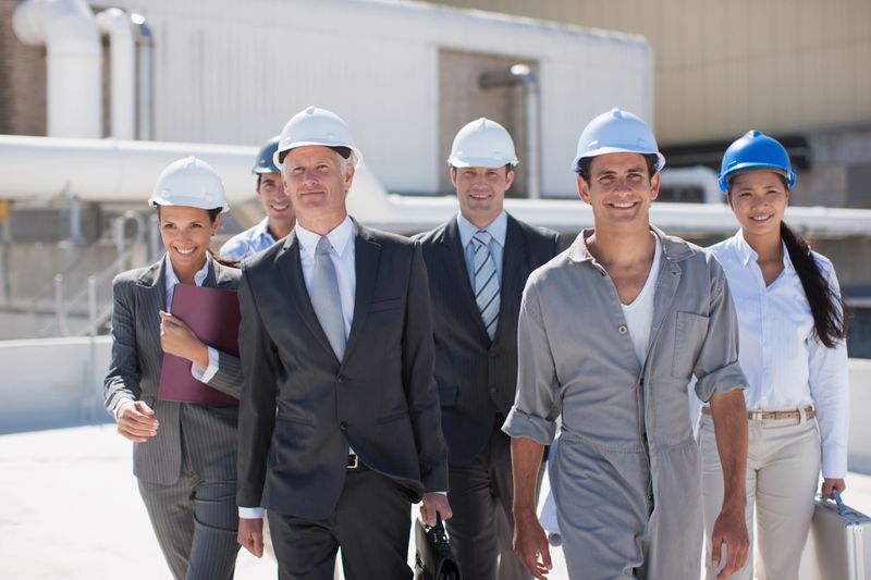 Business people in hard-hats standing together outdoors