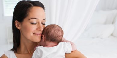 New mother embracing her baby with warmth and love, supported by doula care in Los Angeles.