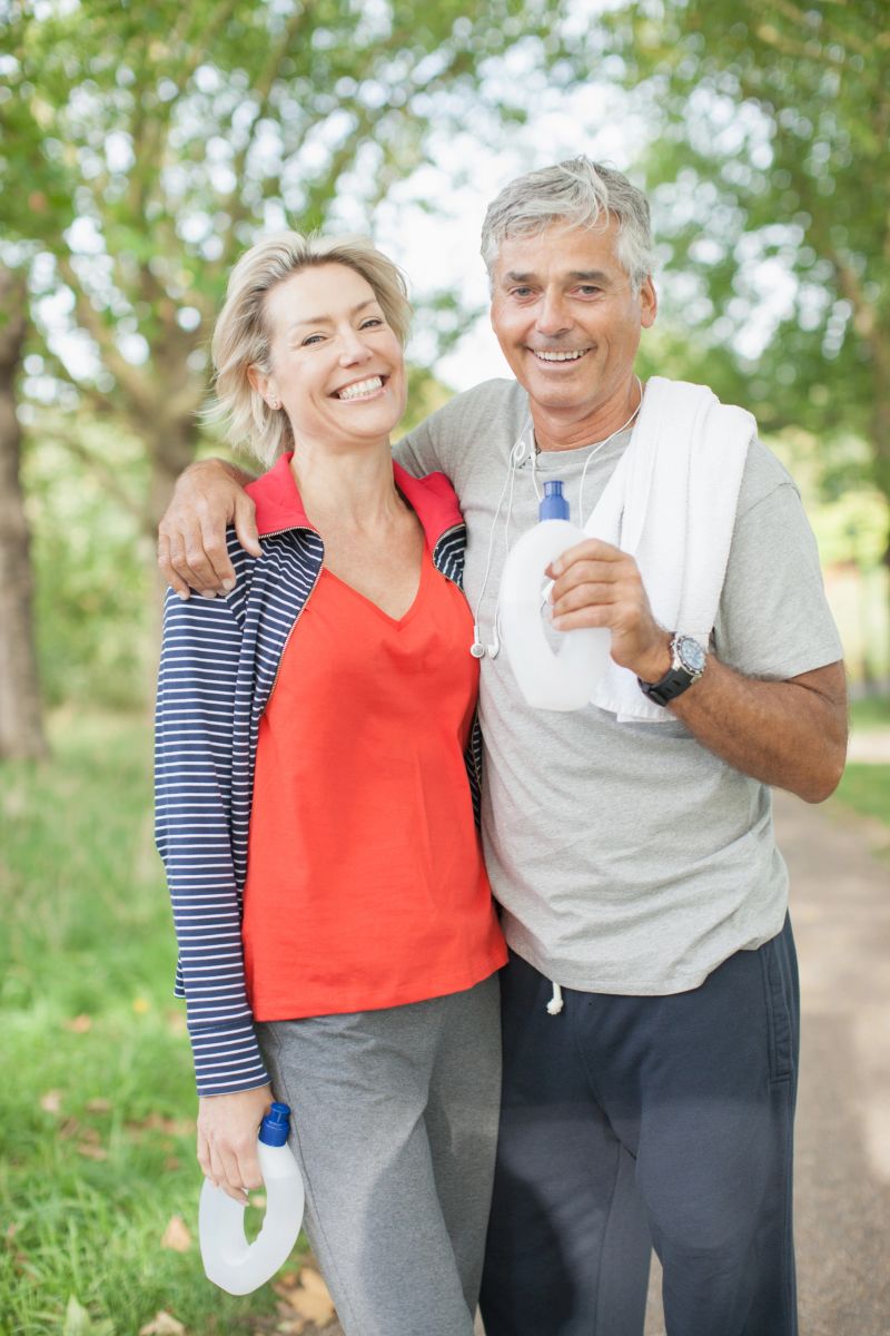 Smiling couple standing together with water bottle